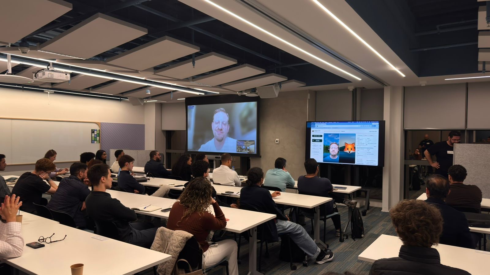 A full room of people watching Jonathan present a live AI demo on screen at AI Tinkerers in Sao Paulo.